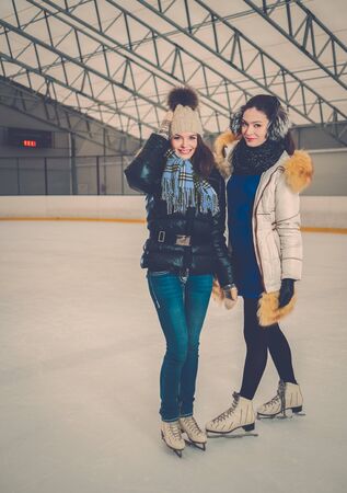 Two girls on ice-skating rinkの写真素材