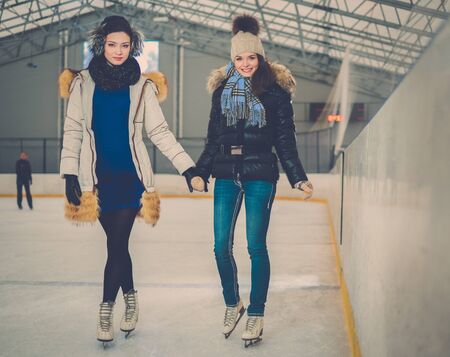Two girls on ice-skating rinkの写真素材
