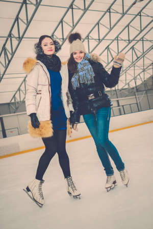 Two girls on ice-skating rinkの写真素材