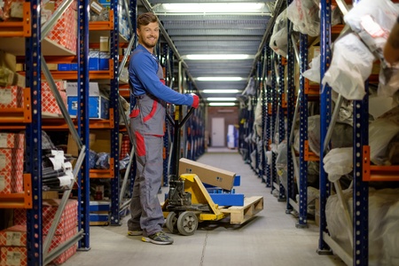 Loader using hand pallet truck in a warehouseの写真素材
