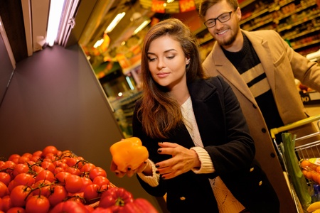 Couple choosing vegetables in a grocery storeの写真素材