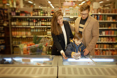 Young family near freezer in a grocery storeの写真素材