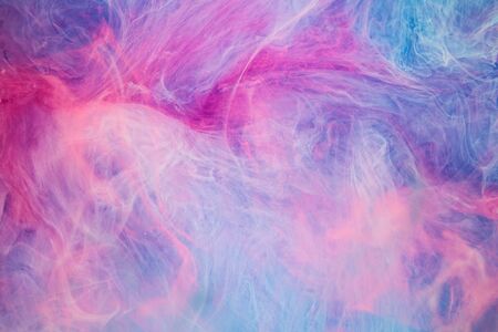Blue pink clouds of ink in liquidの写真素材