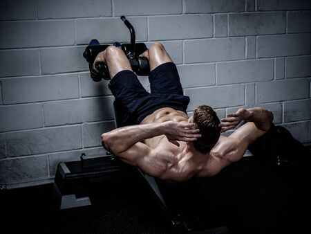 Muscular man doing exercises for abdominal in The Gym's Studio