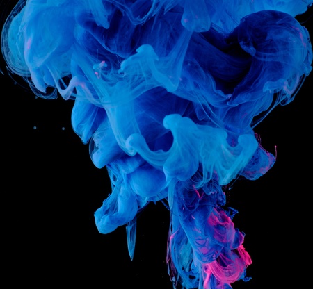 Blue pink clouds of ink in liquid isolated on black