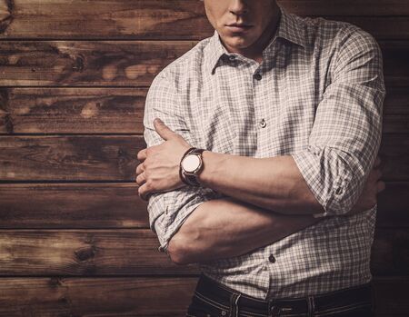 Handsome man wearing checkered  shirt in wooden rural house interiorの写真素材