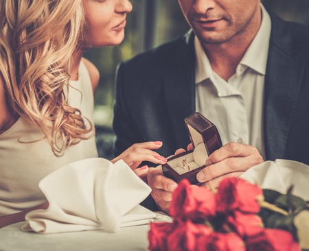Man holding box with ring making propose to his girlfriend