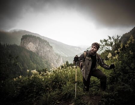 Man with hiking equipment walking in mountain forest