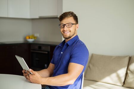 Handsome man using tablet pc at homeの写真素材