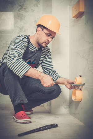 Builder measuring pipe in a bathroomの写真素材
