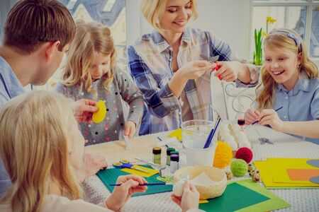 Cheerful family having fun painting and decorating easter eggs.の写真素材