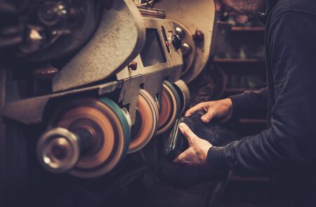 Shoemaker performs shoes in the studio craft grinder machine.の写真素材