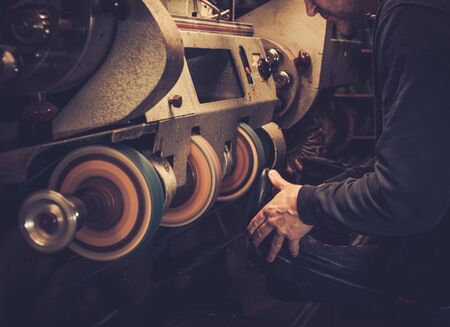 Shoemaker performs shoes in the studio craft grinder machine.の写真素材