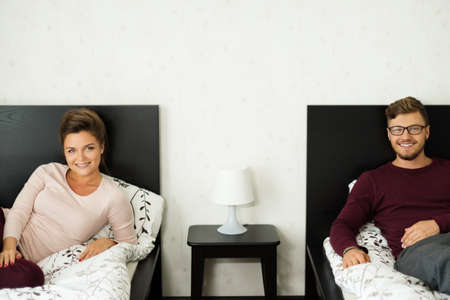 Cheerful couple on a bed at home
