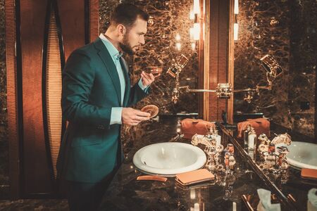 Confident well-dressed man in luxury bathroom interior.の写真素材
