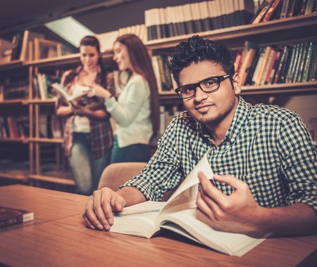 Multinational group of cheerful students studying in the university library.の写真素材