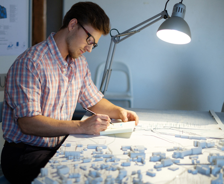 Young architect working on drawing table in architect studio.の写真素材