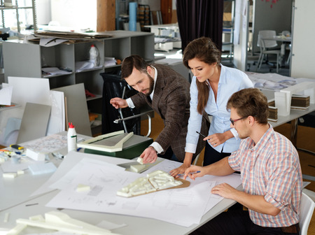 Confident team of engineers working together in a architect studio.