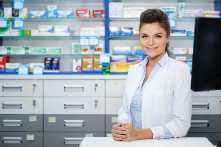 Beautiful smiling young woman pharmacist doing his work in pharmacy.の写真素材