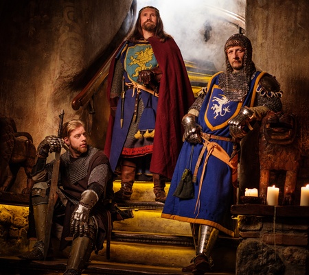 Medieval king with his  knights in ancient castle interior.