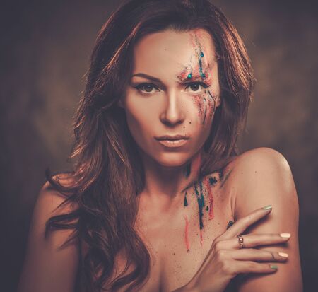Portrait of beautiful woman with creative colored makeup on a dark background.の写真素材
