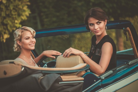 Two stylish ladies in a classic convertibleの写真素材