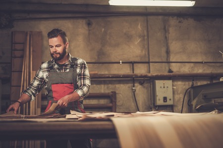 Carpenter doing his job in carpentry workshop.の写真素材