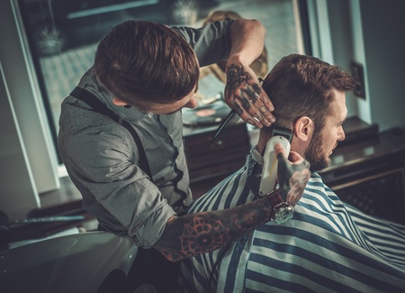Confident man visiting hairstylist in barber shop.