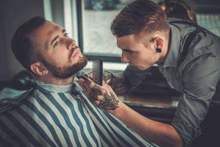 Confident man visiting hairstylist in barber shop.