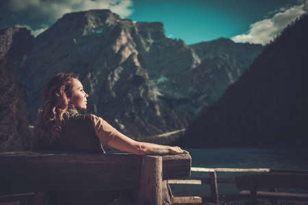 Woman enjoying amazing view of Lago di Braies with mountain forest on the background.の写真素材