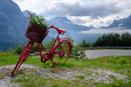 Lonely red decorative bicycle stands on a hillside, Geirangerfjord, Norwayの写真素材