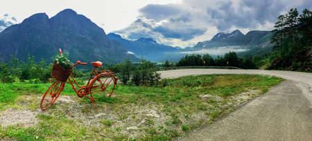 Lonely red decorative bicycle stands on a hillside, Geirangerfjord, Norwayの写真素材