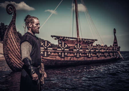 Viking warrior standing near Drakkar on seashore.の写真素材