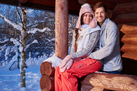 Cheerful couple spend winter holidays at mountain cottage.の写真素材