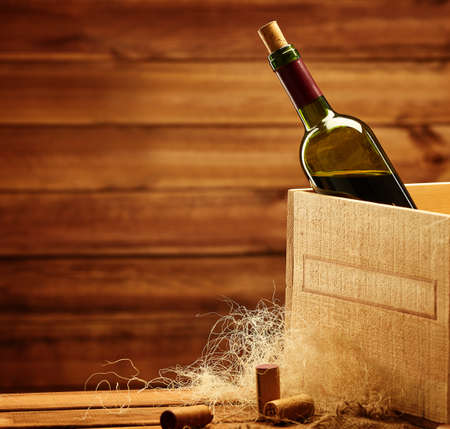 Bottle of wine in box in wooden interior.の写真素材