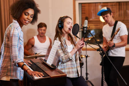 Multiracial music band performing in a recording studio.の写真素材