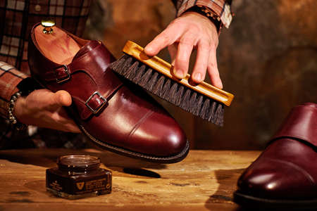 Man polishing leather shoes with brushの写真素材
