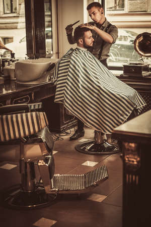 Confident man visiting hairstylist in barber shopの写真素材