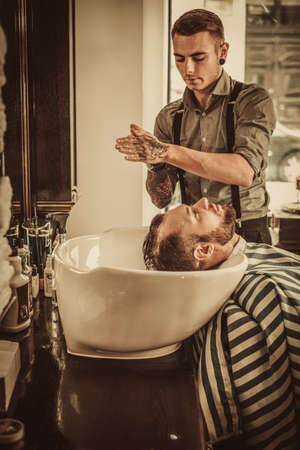 Confident man visiting hairstylist in barber shopの写真素材