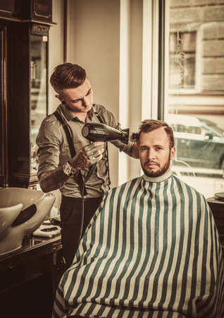 Confident man visiting hairstylist in barber shopの写真素材