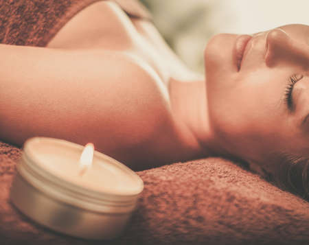 Beautiful young woman having massage in a spa salon.の写真素材
