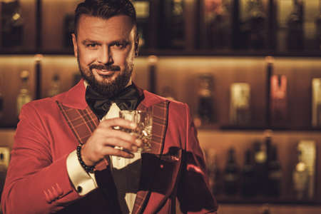 Extravagant stylish man with whisky glass in gentleman club.