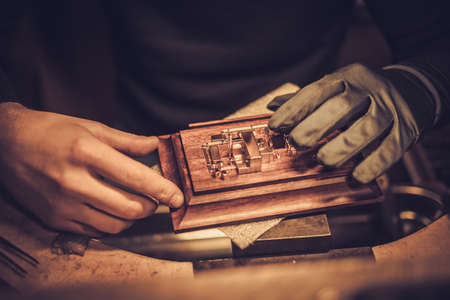 Jeweler at work in jewelery workshop.