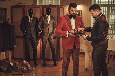 Extravagant man in tailor studio choosing cloth for custom made suit.の写真素材