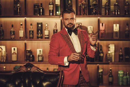 Extravagant stylish man with whisky glass in gentleman club.の写真素材