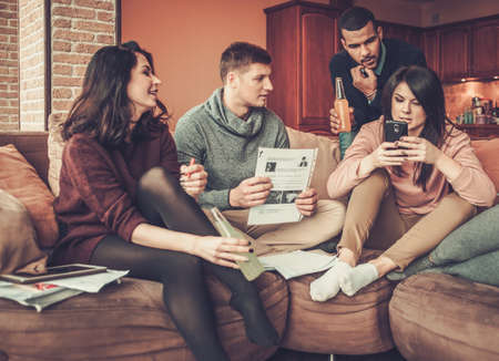 Group of multi ethnic young students preparing for exams in home interior.