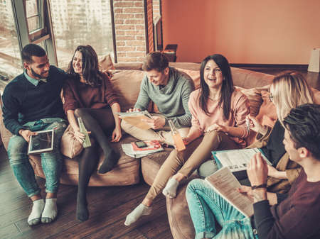Group of multi ethnic young students preparing for exams in home interior.
