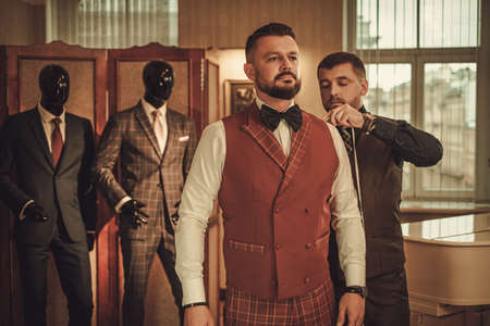 Tailor measuring client for custom made suit tailoring.の写真素材