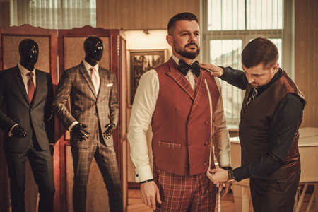 Tailor measuring client for custom made suit tailoring.の写真素材