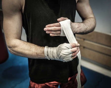 Fighter preparing for training, wrapping hands with boxing wrapsの写真素材